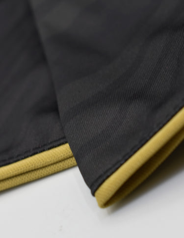 Détail du design noir et or du maillot training Barça 25/26.