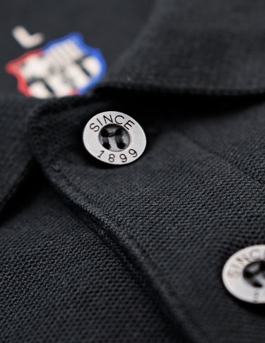 Détail du logo FC Barcelone sur le polo noir.